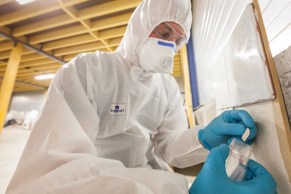 Asbestos consultant collecting sample